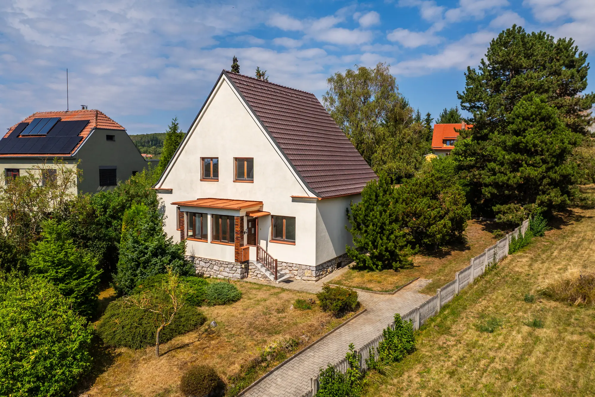 Dům a oplocený pozemek z dronu z boku