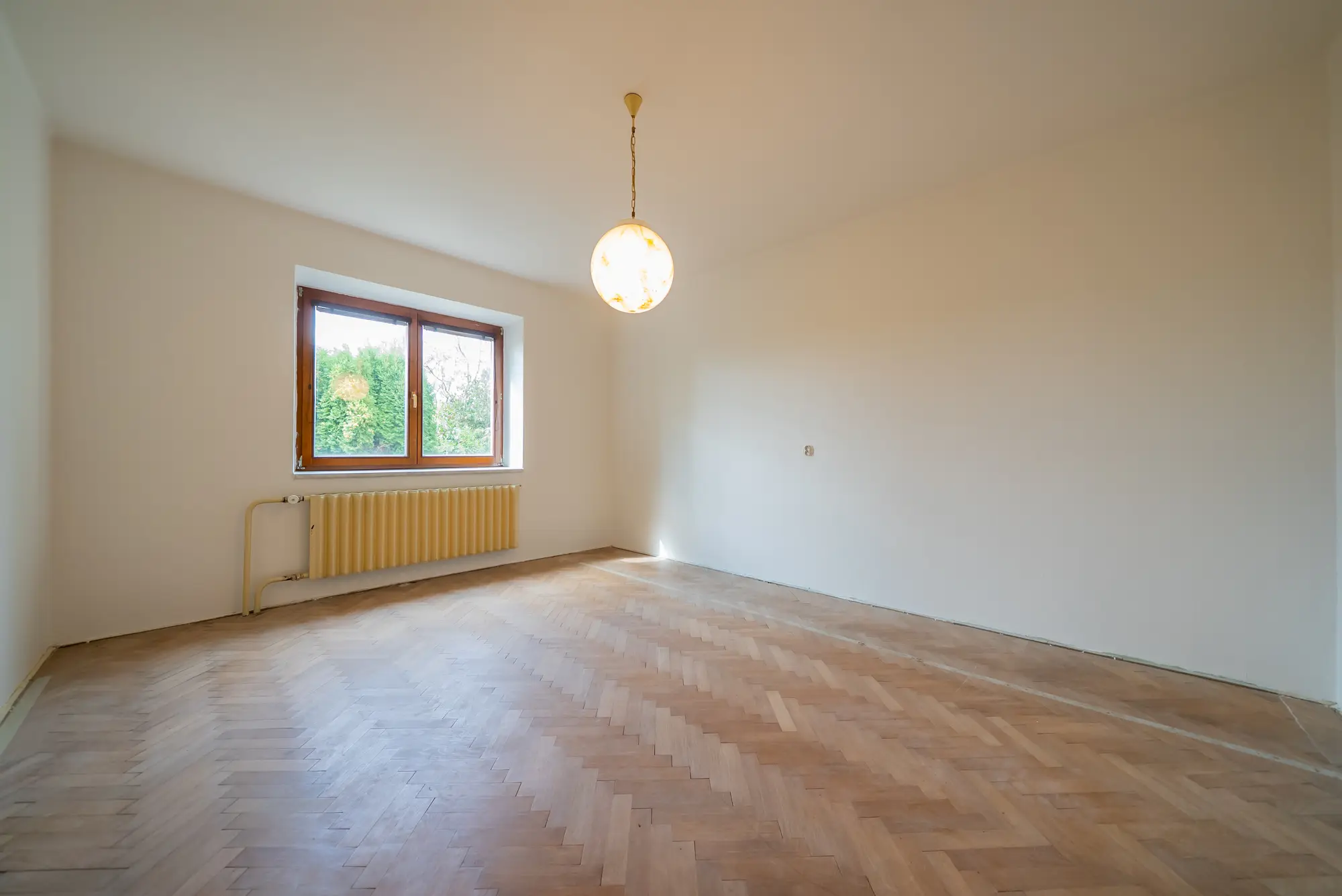 Prostorný pokoj v přízemí s dřevěnou podlahou
