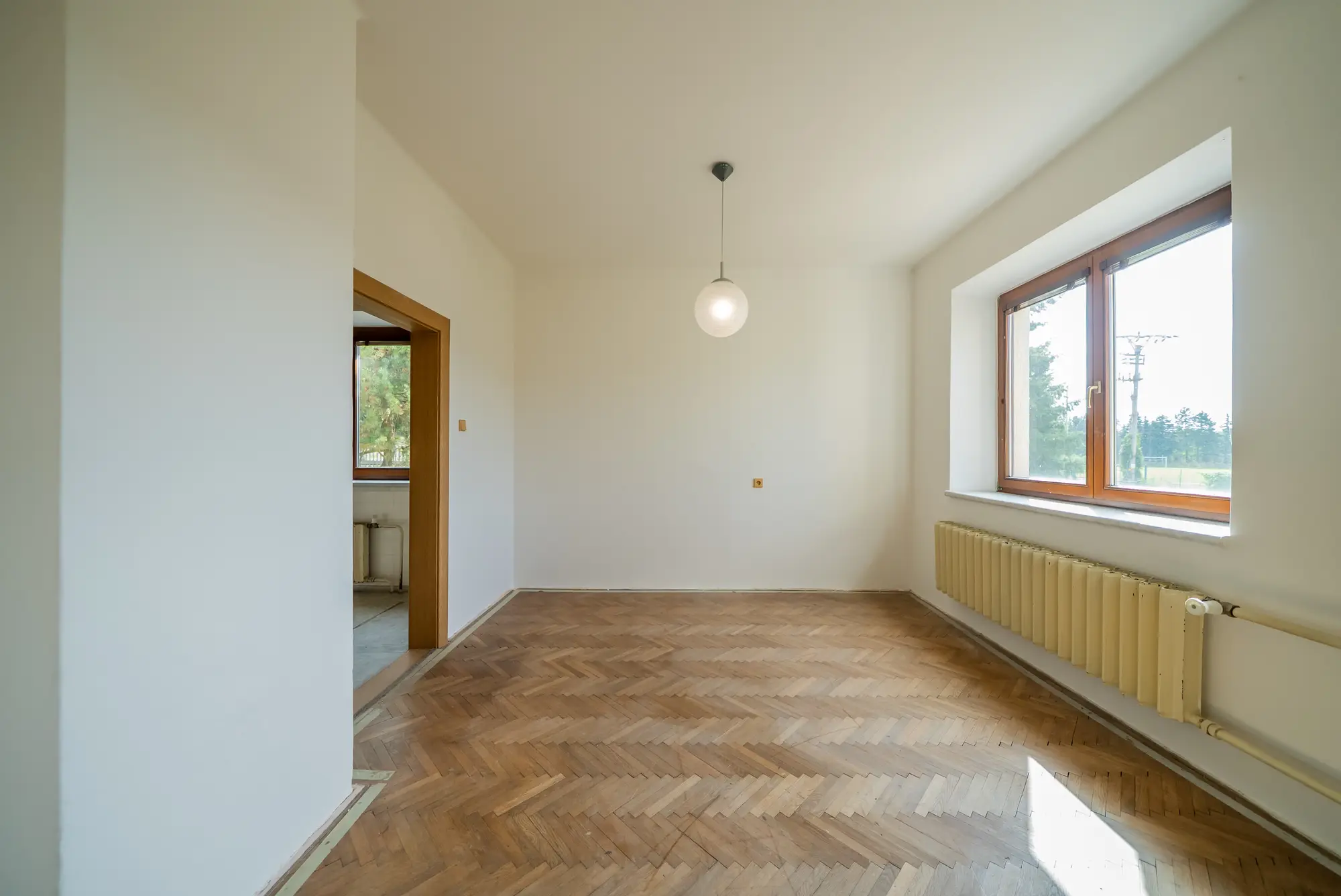 Světlý pokoj v přízemí s oknem do zahrady