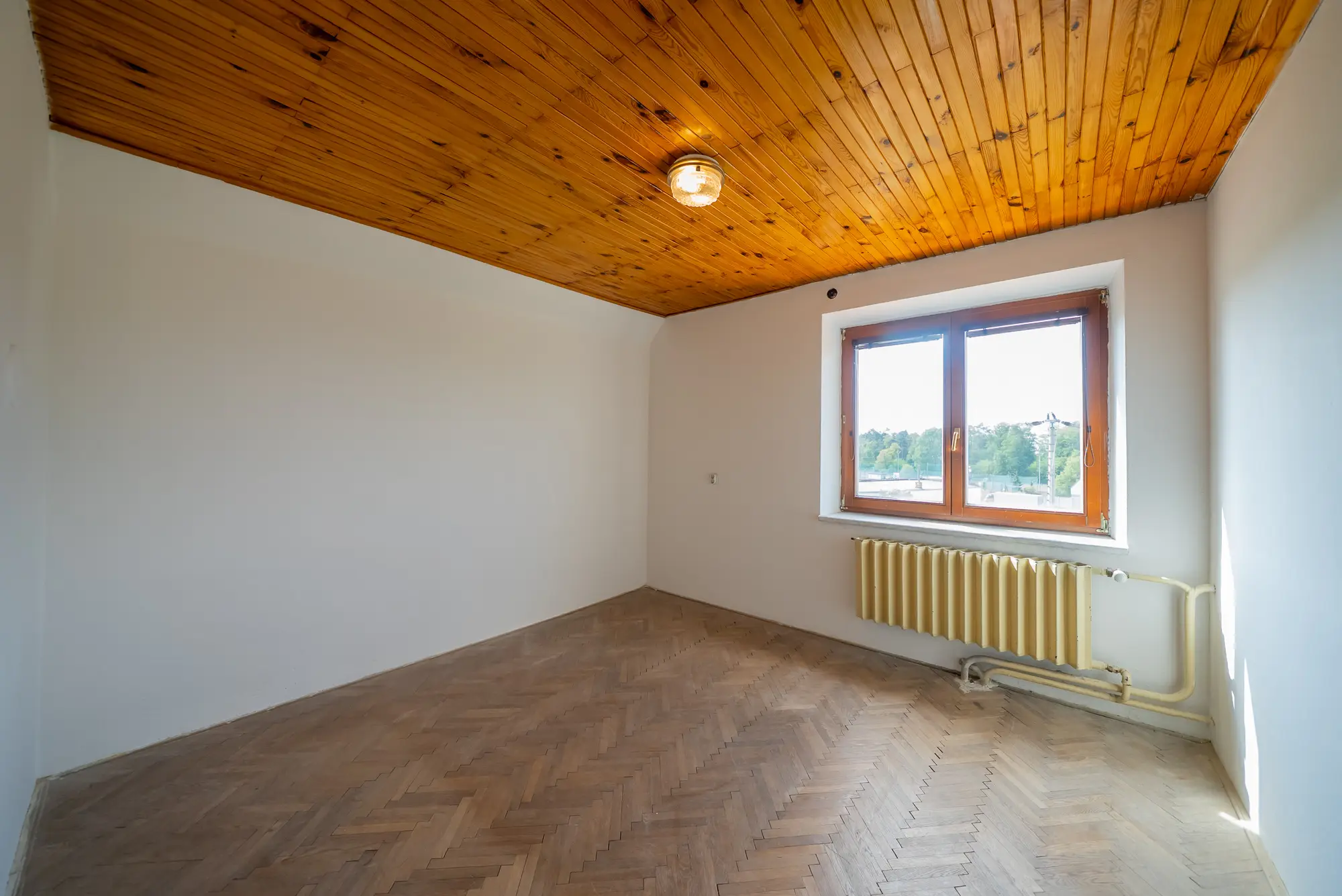 Pokoj v patře s oknem do zahrady